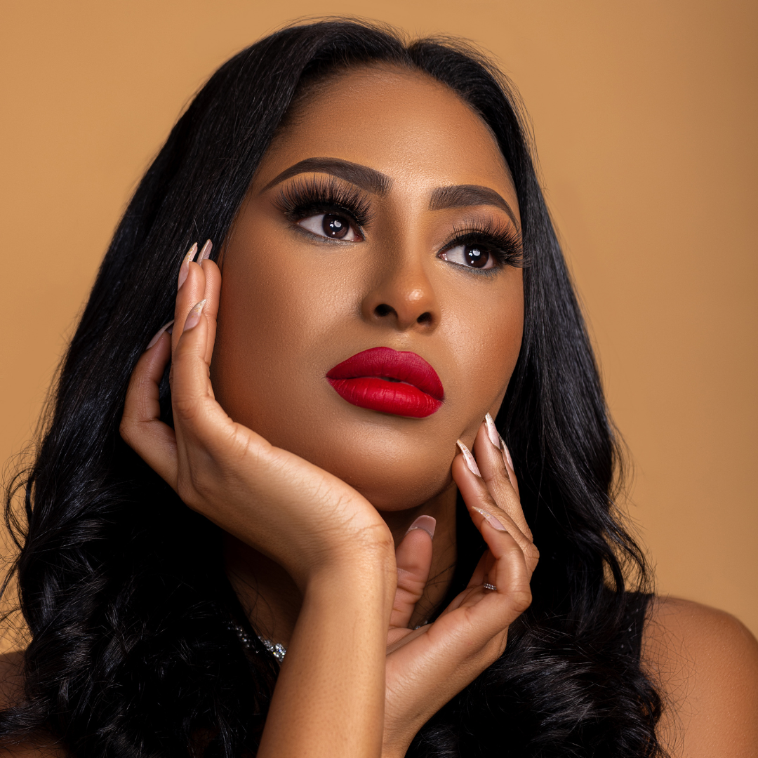 Makeup artist with bold red lipstick and softly glowing makeup